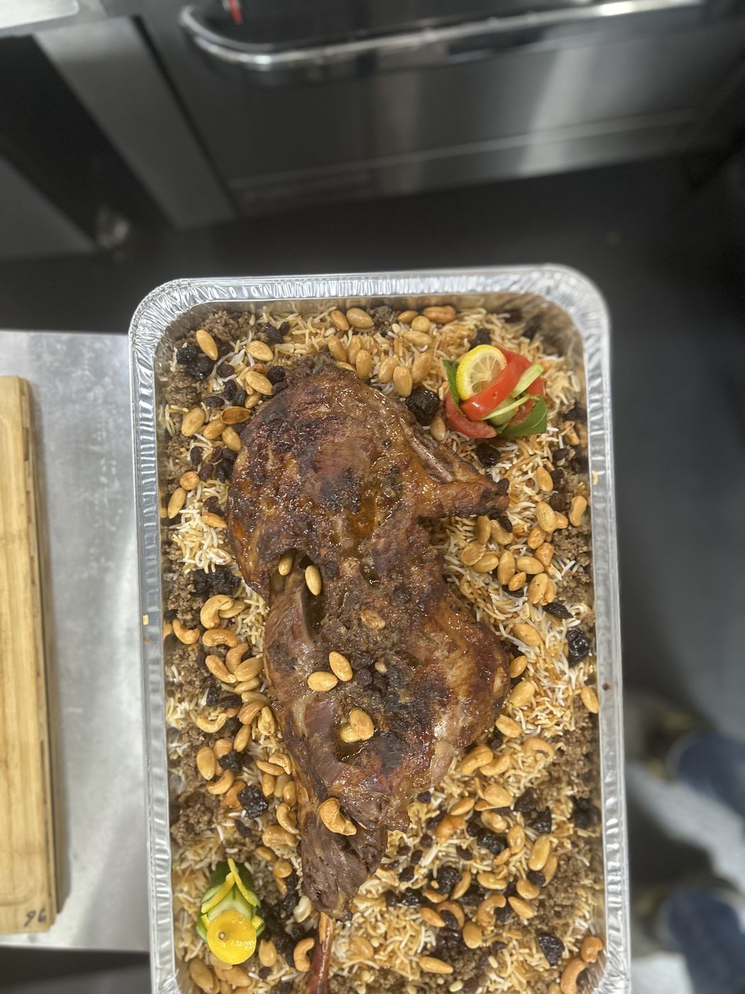 Roast lamb over yellow rice in a catering tray